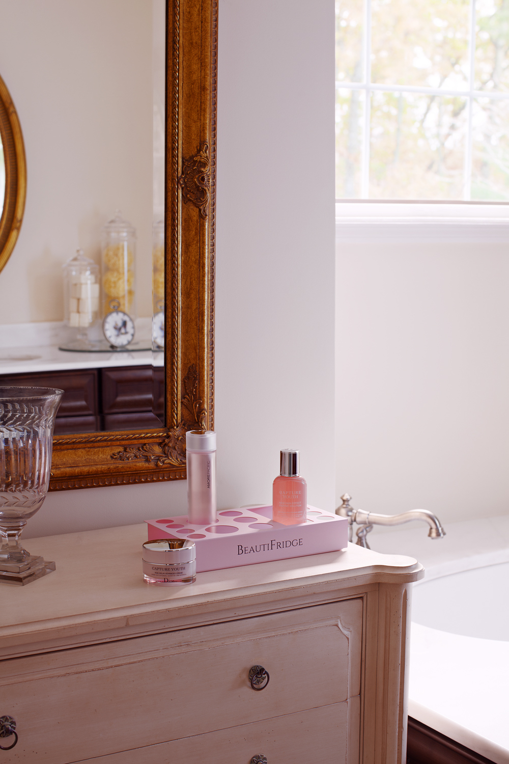 BeautiFridge compact cosmetics cooler with pink trimmed glass door, lock, matte blush pink shelves, and digital controls set for the storage of beauty products